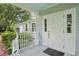 Inviting front porch with classic white railings, blue ceiling, and a view of the landscaped yard at 9223 Silver Lake Dr, Leesburg, FL 34788