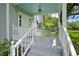 Charming front porch with white railings, a blue ceiling, and steps leading to the landscaped yard at 9223 Silver Lake Dr, Leesburg, FL 34788