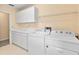 Bright laundry room features cabinetry and newer washer and dryer at 9223 Silver Lake Dr, Leesburg, FL 34788