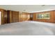 Bright living room with wood paneling, carpeted floors, and built-in closet space at 9223 Silver Lake Dr, Leesburg, FL 34788