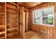 An office featuring wood paneling, a window, hardwood floors, and built-in shelves for ample storage at 9223 Silver Lake Dr, Leesburg, FL 34788