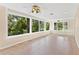 Open sunroom with tile floors, lots of windows providing a lovely view, and multiple ceiling fans at 9223 Silver Lake Dr, Leesburg, FL 34788