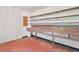 Functional utility room with built-in shelving, workspace, and red tile flooring at 9223 Silver Lake Dr, Leesburg, FL 34788