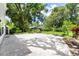 Large paved patio and yard with lush trees and landscaping at 9223 Silver Lake Dr, Leesburg, FL 34788