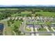 Neighborhood aerial view showcasing a pond and verdant green spaces at 9702 Pepper Tree Pl, Wildwood, FL 34785
