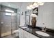 Stylish bathroom featuring a double vanity, granite countertops, and a tiled glass shower at 9702 Pepper Tree Pl, Wildwood, FL 34785
