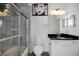 Modern bathroom featuring tiled walk-in shower with glass door and granite vanity at 9702 Pepper Tree Pl, Wildwood, FL 34785