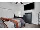 Comfortable bedroom with modern bed frame, TV, ceiling fan, and double closet doors at 9702 Pepper Tree Pl, Wildwood, FL 34785