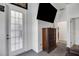 Bright foyer featuring a glass door, dark wood cabinet and mounted television at 9702 Pepper Tree Pl, Wildwood, FL 34785