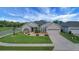 Charming single-Gathering home with manicured lawn, landscaped garden beds, and a two-car garage at 9702 Pepper Tree Pl, Wildwood, FL 34785