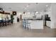 Spacious white kitchen with stainless steel appliances, a center island, and a breakfast bar at 9702 Pepper Tree Pl, Wildwood, FL 34785