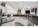 Bright kitchen features white cabinetry, stainless steel appliances, granite counters, a large island and open floor plan at 9702 Pepper Tree Pl, Wildwood, FL 34785
