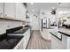 Modern kitchen featuring white cabinetry, stainless steel appliances, granite counters and wood-look tile flooring at 9702 Pepper Tree Pl, Wildwood, FL 34785