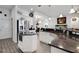 Modern kitchen with stainless steel appliances, white cabinets, granite countertops, and an open layout at 9702 Pepper Tree Pl, Wildwood, FL 34785