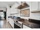Well-appointed kitchen featuring stainless steel range, hood, granite counters, and sleek white cabinetry at 9702 Pepper Tree Pl, Wildwood, FL 34785