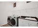 Bright laundry room featuring modern washer and dryer set, sink, and plenty of storage space at 9702 Pepper Tree Pl, Wildwood, FL 34785