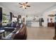 Spacious living room with hardwood floors, leather sofa, open floorplan, and modern decor at 9702 Pepper Tree Pl, Wildwood, FL 34785