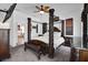 Elegant main bedroom featuring a four-poster bed, ceiling fan and neutral carpeting at 9702 Pepper Tree Pl, Wildwood, FL 34785