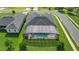 Aerial view of a private screened-in pool with outdoor seating and a well-kept lawn at 9702 Pepper Tree Pl, Wildwood, FL 34785