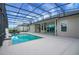 Relaxing screened-in pool area with covered patio and modern lounge chairs at 9702 Pepper Tree Pl, Wildwood, FL 34785
