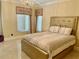 Bedroom showcases a bed with a padded headboard and chandelier lighting, with beige and light colors at 10301 Savannah Ridge Ln, Winter Garden, FL 34787