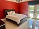 Bright bedroom with red walls, decorative chandelier, and door to outdoor space at 10301 Savannah Ridge Ln, Winter Garden, FL 34787