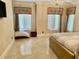 Bedroom view with chandelier, two windows, tiled floors, beige walls, and furnishings at 10301 Savannah Ridge Ln, Winter Garden, FL 34787