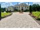 Elegant two-story home with a fountain, manicured lawn, and paver driveway at 10301 Savannah Ridge Ln, Winter Garden, FL 34787