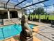 Screened pool area with a lion statue, manicured lawn, and a glimpse of the surrounding landscape at 10301 Savannah Ridge Ln, Winter Garden, FL 34787