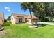 Inviting home showcasing a lush green lawn, mature palm trees, and an attached two-car garage at 1032 Ventura Dr, Lady Lake, FL 32159