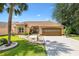 Charming single-story home with a well-maintained lawn, mature landscaping, and a two-car garage at 1032 Ventura Dr, Lady Lake, FL 32159