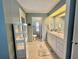 Well-lit bathroom featuring white cabinets and tile flooring at 113 Temple W Cv, Leesburg, FL 34748
