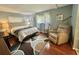 Well-lit bedroom with a comfortable chair, queen-sized bed, and stylish accents for a relaxing ambiance at 113 Temple W Cv, Leesburg, FL 34748