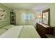 Bright bedroom with neutral tones, dresser with mirror, and sheer curtains for natural light, creating a peaceful space at 113 Temple W Cv, Leesburg, FL 34748