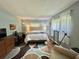 Cozy bedroom featuring a queen-sized bed, stylish rug, desk, dresser, and comfortable chair for relaxation at 113 Temple W Cv, Leesburg, FL 34748