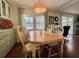 Bright dining area featuring a wooden table with seating for four, and a sliding glass door at 113 Temple W Cv, Leesburg, FL 34748