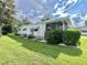 Charming mobile home featuring manicured lawn and tasteful landscaping at 113 Temple W Cv, Leesburg, FL 34748