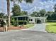 Charming home featuring a screened porch, carport, and well-maintained landscaping at 113 Temple W Cv, Leesburg, FL 34748