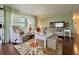Cozy living room offering a neutral sofa, loveseat, patterned rug and abundant natural lighting at 113 Temple W Cv, Leesburg, FL 34748