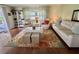 Bright living room with wood floors, a decorative rug, comfortable seating, and lots of natural light at 113 Temple W Cv, Leesburg, FL 34748