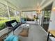Screened-in porch with sliding glass door and comfortable seating area at 113 Temple W Cv, Leesburg, FL 34748
