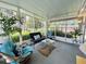 Bright screened-in porch with stylish seating and a view of the community at 113 Temple W Cv, Leesburg, FL 34748
