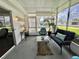 Inviting screened-in porch with cozy blue seating, plants, and natural light at 113 Temple W Cv, Leesburg, FL 34748