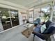 Bright screened-in porch with charming decor, plants, and cozy seating at 113 Temple W Cv, Leesburg, FL 34748