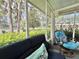 Cozy screened-in porch with a comfortable blue sofa and lush green surroundings at 113 Temple W Cv, Leesburg, FL 34748
