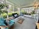 Comfortable screened-in porch with plush blue cushions and decorative accents at 113 Temple W Cv, Leesburg, FL 34748