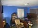 Blue bedroom featuring vintage furniture, window, and space for a queen-size bed at 11651 Fairmont Ave, Leesburg, FL 34788