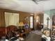 Cozy living room features paneled walls, vintage furnishings and adjacent dining area at 11651 Fairmont Ave, Leesburg, FL 34788