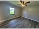 Bedroom showcasing gray wood-look flooring and a window allowing ample natural light at 11681 Se 72Nd Court Rd, Belleview, FL 34420