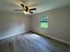 Bedroom featuring neutral walls, wood-look flooring, and a bright window overlooking the yard at 11681 Se 72Nd Court Rd, Belleview, FL 34420